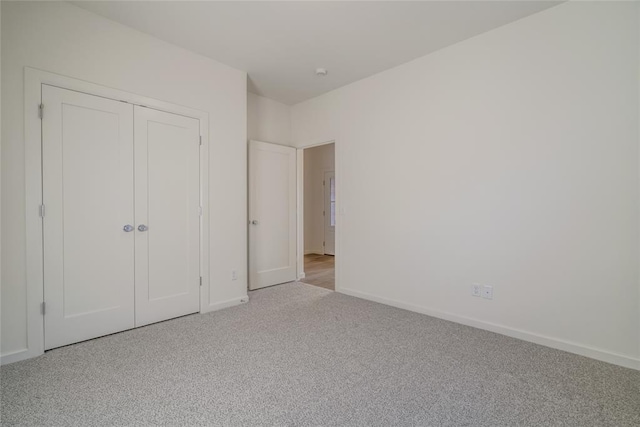 unfurnished bedroom featuring light colored carpet and a closet