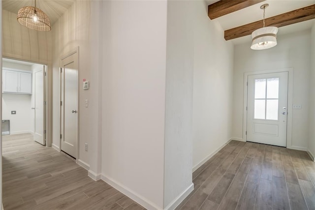 entrance foyer featuring beam ceiling, wood-type flooring, and an inviting chandelier