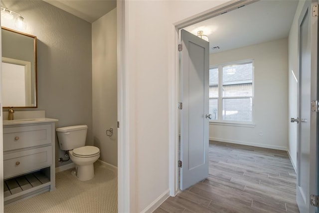 bathroom with vanity, hardwood / wood-style flooring, and toilet