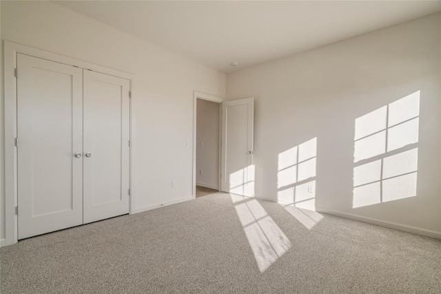 unfurnished bedroom with light carpet and a closet