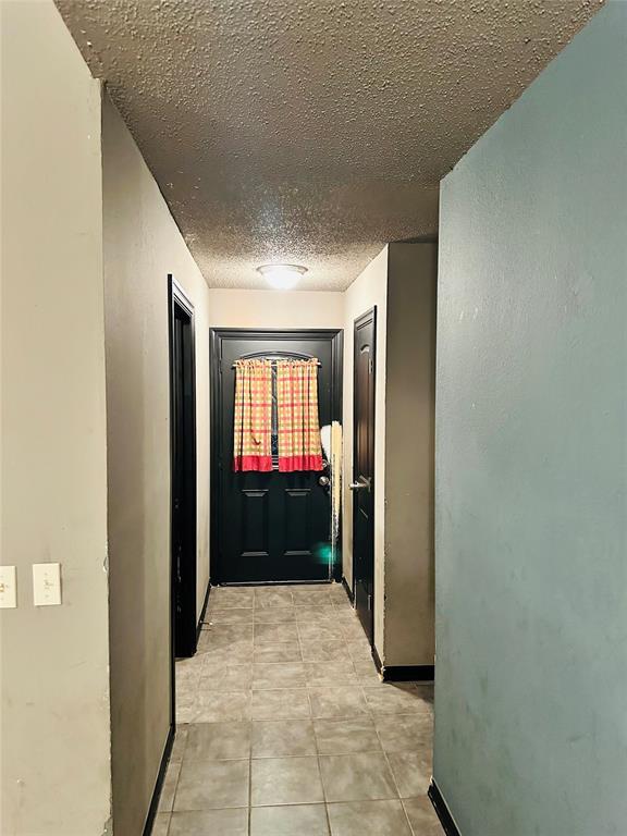 corridor featuring a textured ceiling