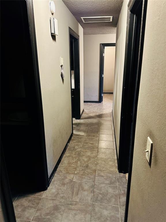 8912 Muriel Way, Spencer, OK 73084 - corridor with a textured ceiling, baseboards, and light tile patterned floors