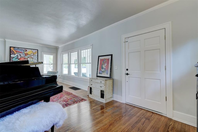 misc room featuring wood-type flooring and ornamental molding