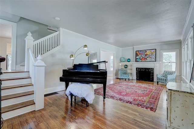 living area featuring hardwood / wood-style flooring and crown molding