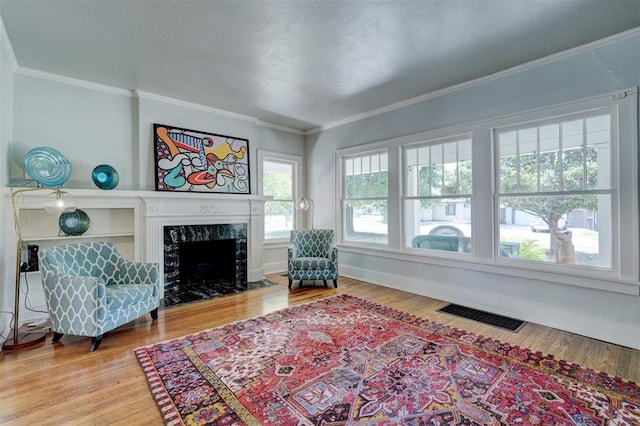 living room with a premium fireplace, hardwood / wood-style floors, and ornamental molding