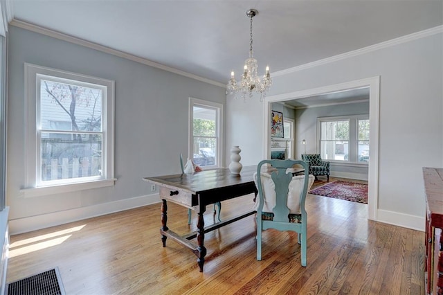 dining space with a chandelier, hardwood / wood-style flooring, and crown molding