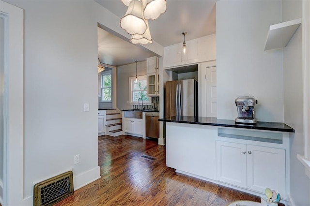 kitchen with stainless steel appliances, sink, pendant lighting, white cabinets, and dark hardwood / wood-style floors