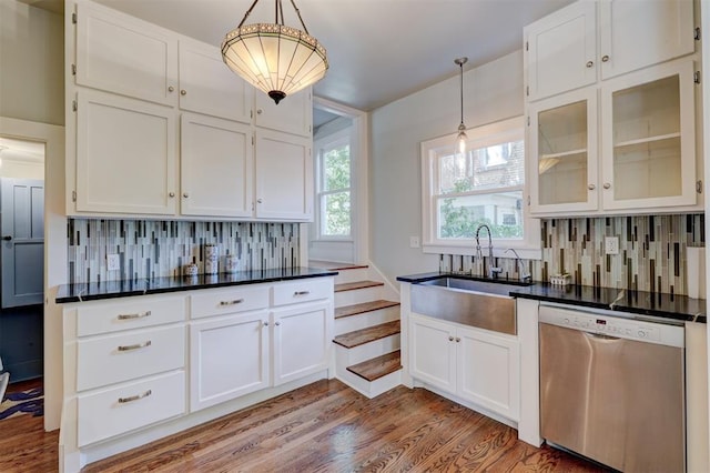 kitchen featuring backsplash, sink, dishwasher, white cabinetry, and hanging light fixtures