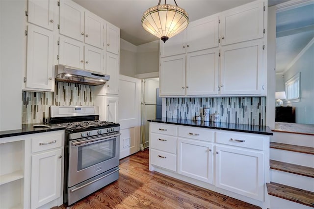 kitchen featuring backsplash, white cabinetry, decorative light fixtures, and stainless steel gas range