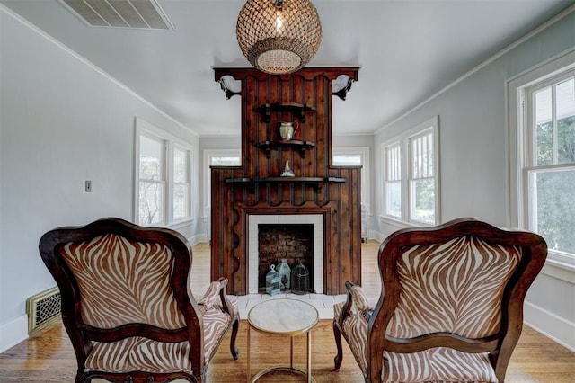 living area featuring light wood-type flooring and crown molding