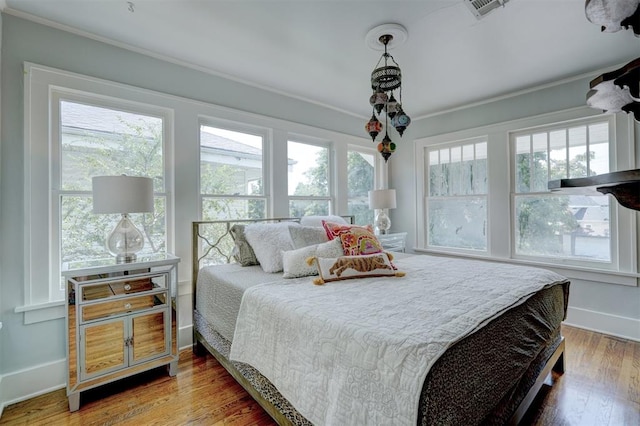 bedroom featuring crown molding and wood-type flooring