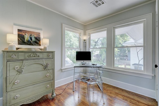 home office featuring plenty of natural light, wood-type flooring, and ornamental molding