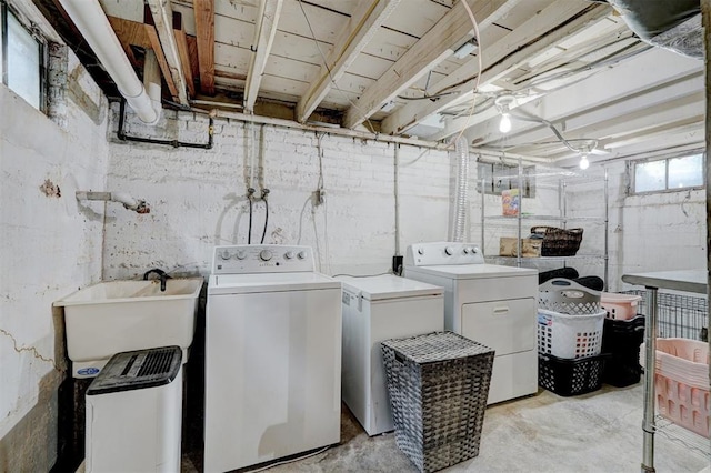 laundry area featuring separate washer and dryer, a healthy amount of sunlight, and sink