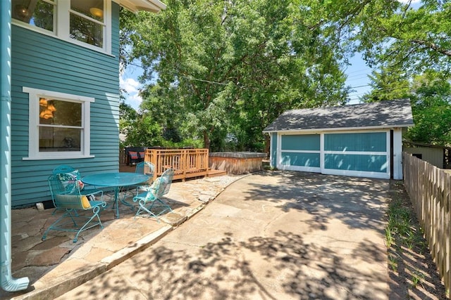 view of patio with a garage, an outdoor structure, and a wooden deck