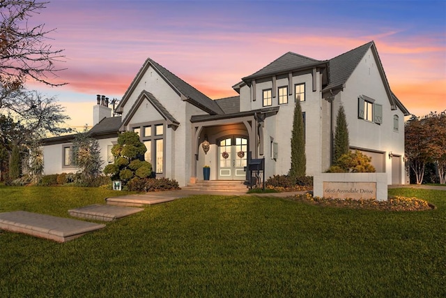 view of front of property with french doors and a lawn