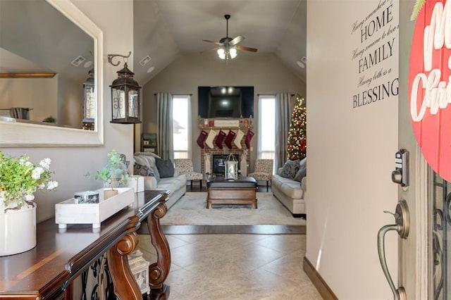 tiled living room with a fireplace, ceiling fan, and lofted ceiling