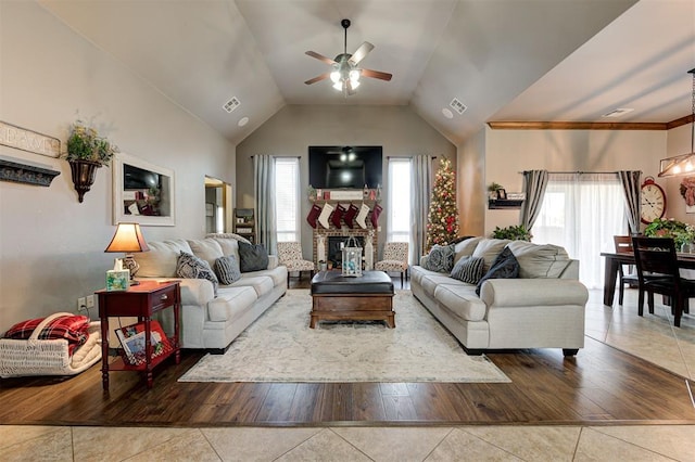 living room with ceiling fan, light hardwood / wood-style floors, and vaulted ceiling