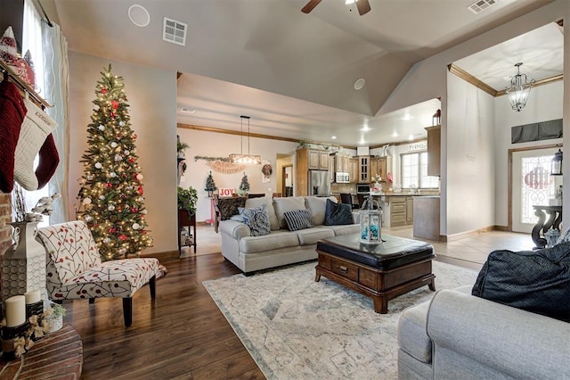 living room featuring ornamental molding, ceiling fan with notable chandelier, sink, hardwood / wood-style floors, and lofted ceiling