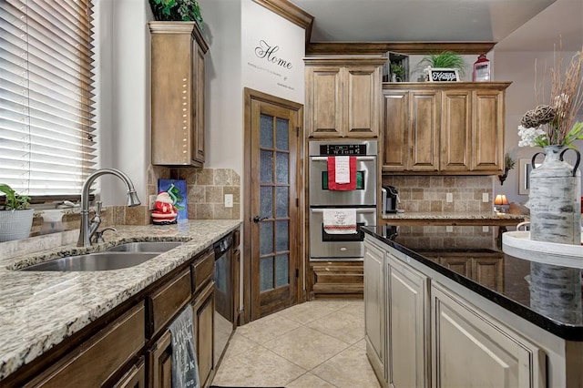 kitchen featuring decorative backsplash, light stone counters, sink, and stainless steel appliances