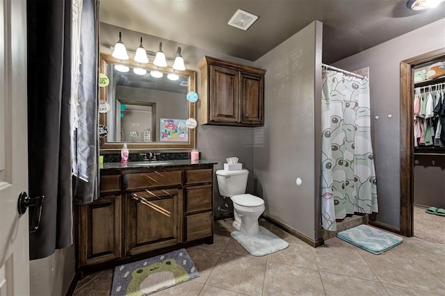 bathroom featuring toilet, a shower with curtain, vanity, and tile patterned floors