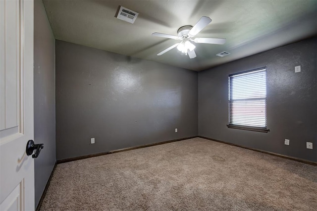 carpeted spare room featuring ceiling fan