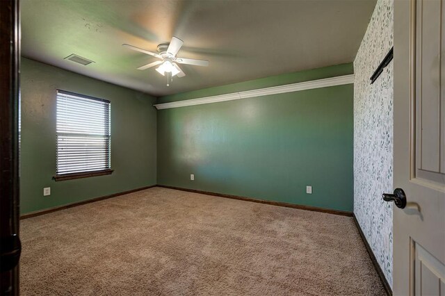 unfurnished room with ceiling fan and light carpet