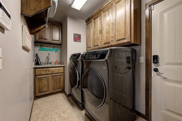 laundry area featuring washing machine and dryer, sink, and cabinets