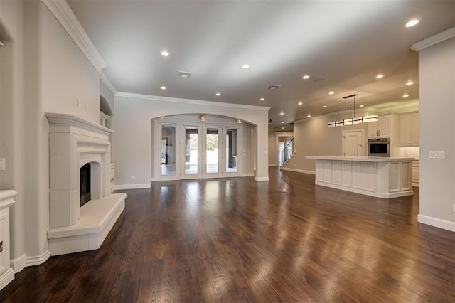 unfurnished living room with french doors, dark hardwood / wood-style flooring, and ornamental molding