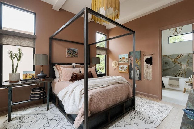 bedroom featuring beamed ceiling, a high ceiling, and light hardwood / wood-style flooring