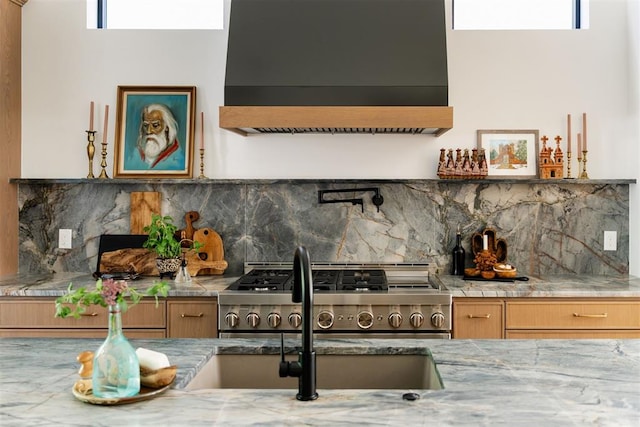 kitchen with plenty of natural light, sink, exhaust hood, and tasteful backsplash