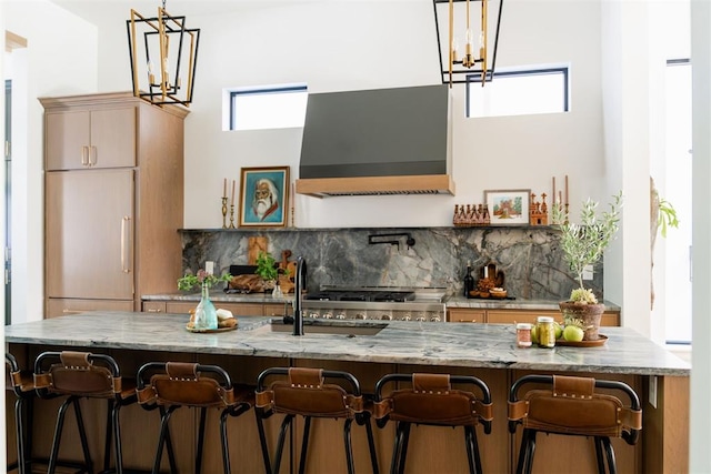 kitchen featuring a healthy amount of sunlight, decorative light fixtures, and ventilation hood