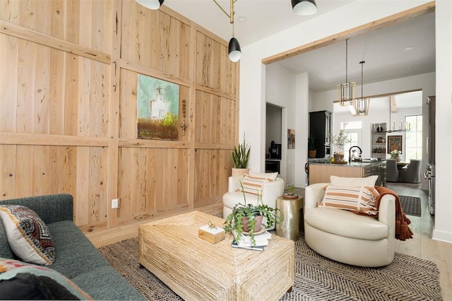 sitting room with wood-type flooring, sink, and wooden walls