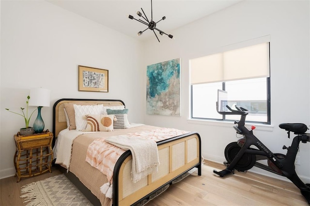 bedroom featuring light hardwood / wood-style flooring and a notable chandelier