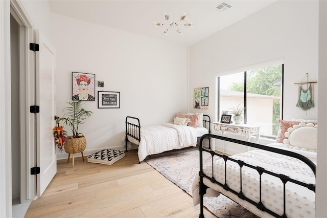 bedroom featuring a chandelier and light hardwood / wood-style flooring