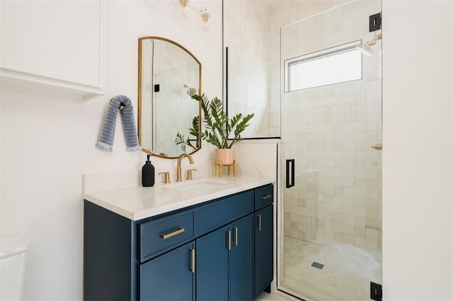 bathroom with vanity, toilet, and a shower with shower door