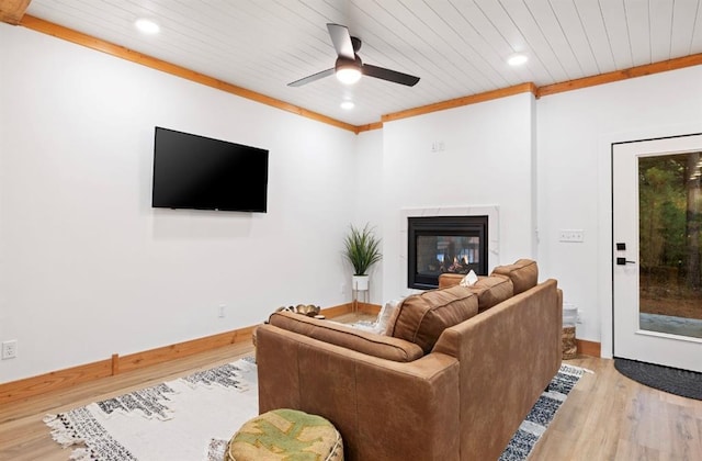 living room with crown molding, ceiling fan, and light wood-type flooring