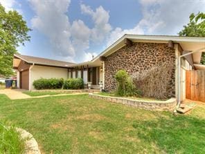 view of front of property with a front yard and a garage