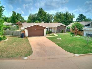 ranch-style house featuring a garage and a front lawn