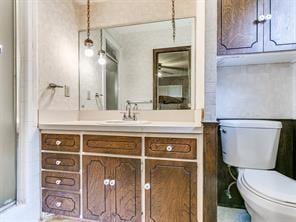 bathroom featuring vanity, a shower with shower door, and toilet