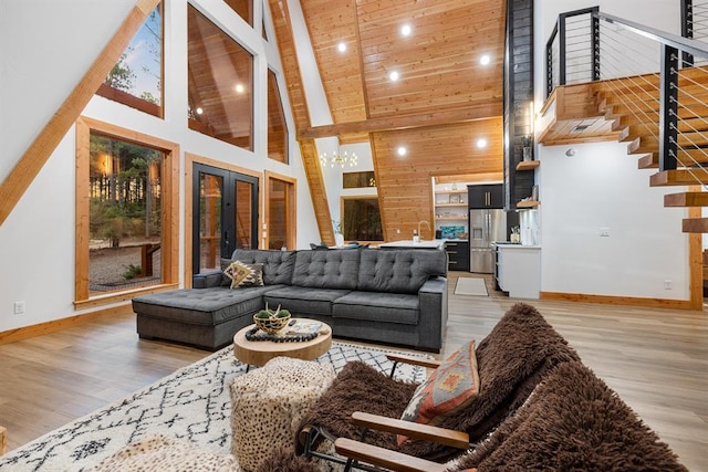 living room featuring high vaulted ceiling, french doors, beamed ceiling, light hardwood / wood-style floors, and wood ceiling