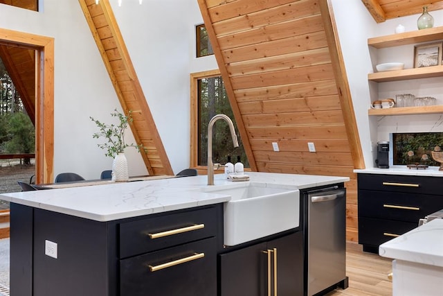 kitchen with light stone countertops, a wealth of natural light, sink, and light hardwood / wood-style floors