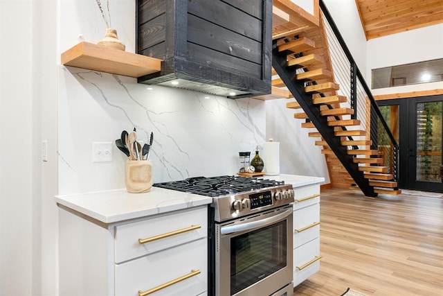 kitchen featuring white cabinets, stainless steel range, tasteful backsplash, light hardwood / wood-style floors, and wood ceiling