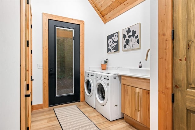 clothes washing area featuring sink, cabinets, wooden ceiling, light hardwood / wood-style floors, and washer and dryer