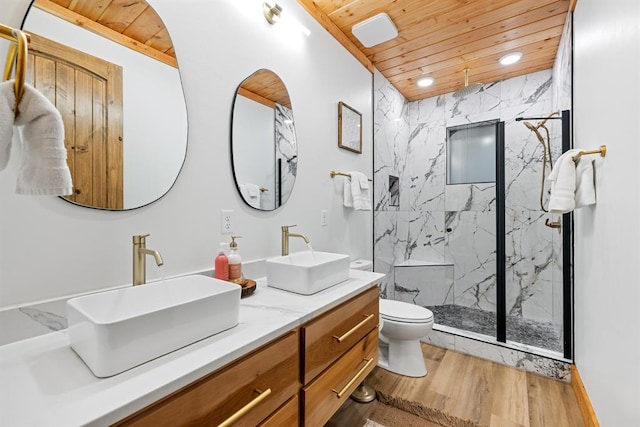 bathroom with hardwood / wood-style floors, vanity, wooden ceiling, toilet, and a tile shower