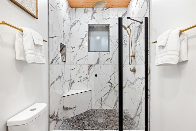 bathroom with toilet and a tile shower