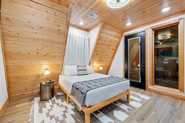 bedroom featuring wooden walls, light hardwood / wood-style flooring, and wood ceiling