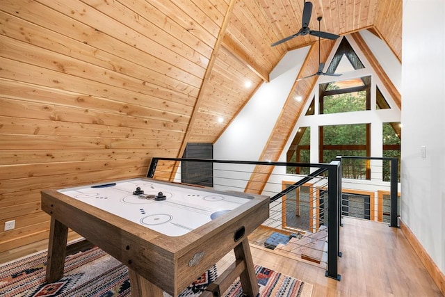 recreation room with wood ceiling, ceiling fan, wooden walls, light hardwood / wood-style floors, and lofted ceiling