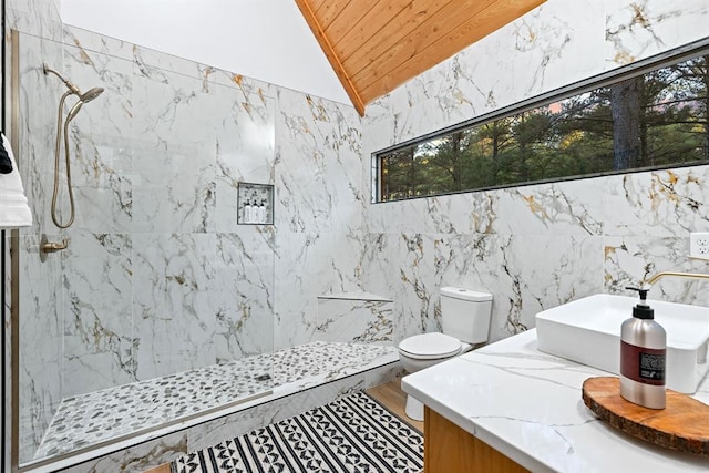 bathroom with plenty of natural light, a tile shower, lofted ceiling, and tile walls