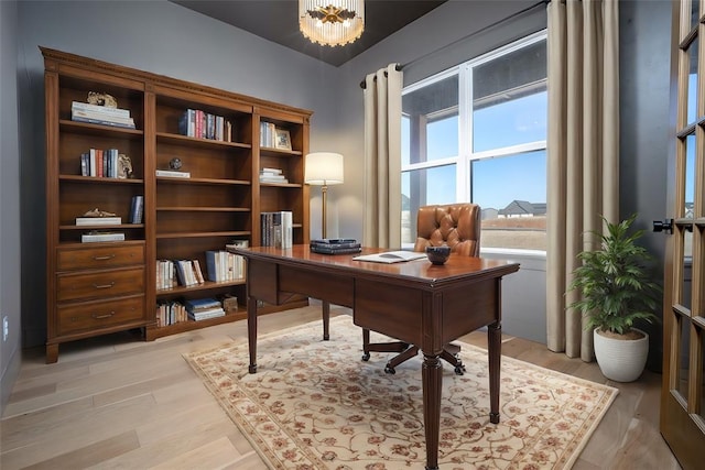 office with a chandelier and light wood-type flooring