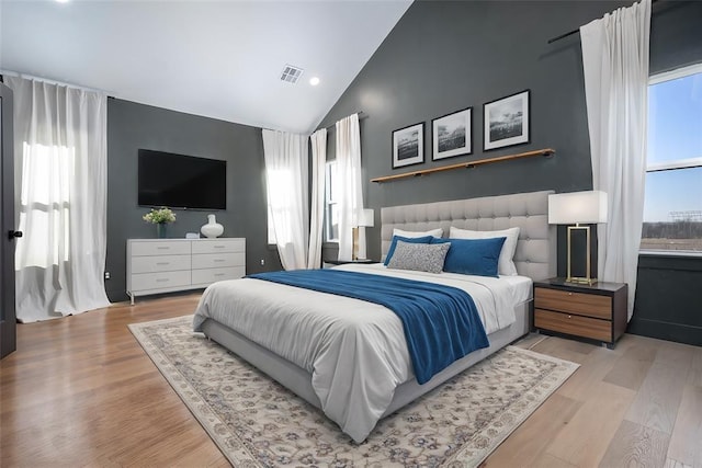 bedroom with light hardwood / wood-style floors and lofted ceiling